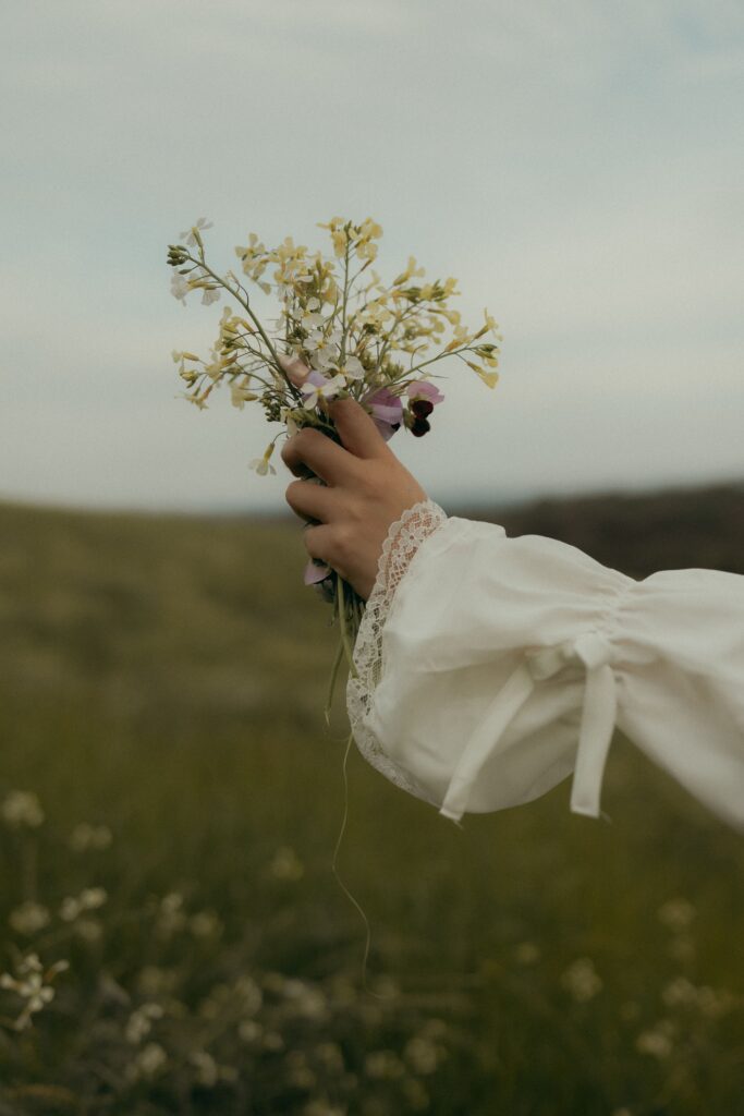 A bride’s hand holding wild flowers